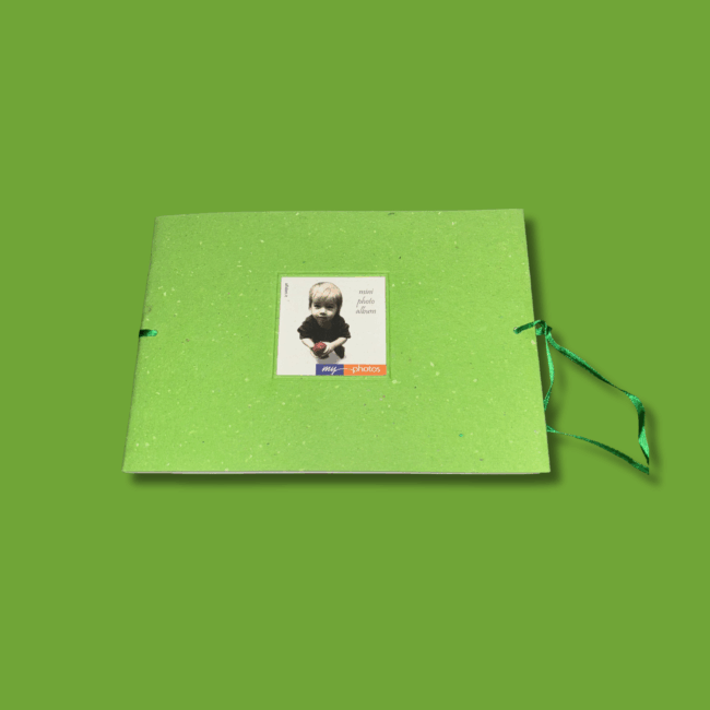Album fotografico compatto “My Photos” con copertina verde in carta riciclata, nastrino laterale e spazio per 12 foto, su sfondo verde coordinato.